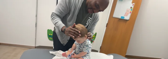Dr. Cooley examining an infants neck and spine